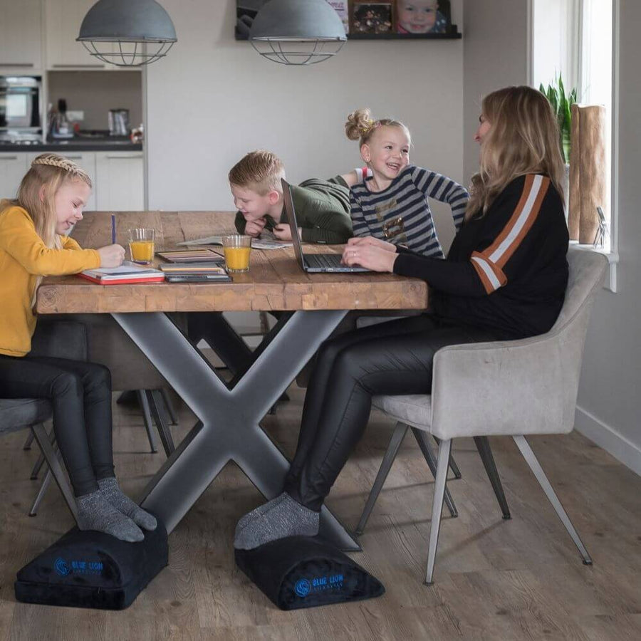 Gezin aan de eettafel met de Blue Lion verstelbare voetensteun op twee hoogtes